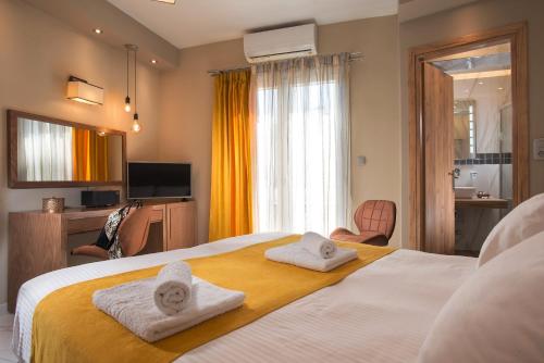 una camera d'albergo con due asciugamani su un letto di Angelica's Deluxe Rooms in Adamas ad Adámas