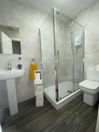 uma casa de banho com um chuveiro, um WC e um lavatório. em Paisley Central Apartment #4 em Paisley