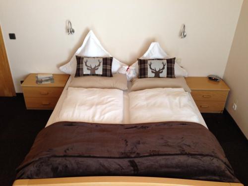 a bedroom with a large bed with two night stands at Mosel-Pension Gästehaus Christiane, Brodenbach in Brodenbach