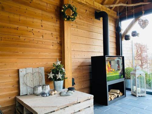 eine Holzwand mit einem Tisch und einem TV auf einer Terrasse in der Unterkunft Mijn Rust in Jabbeke