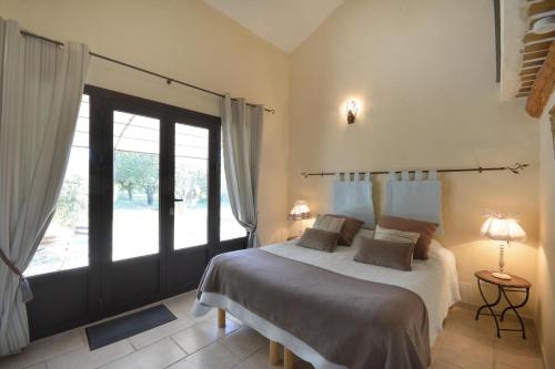 sypialnia z łóżkiem i dużym oknem w obiekcie Chambres d'hôtes Le Vignoble w mieście Cucuron