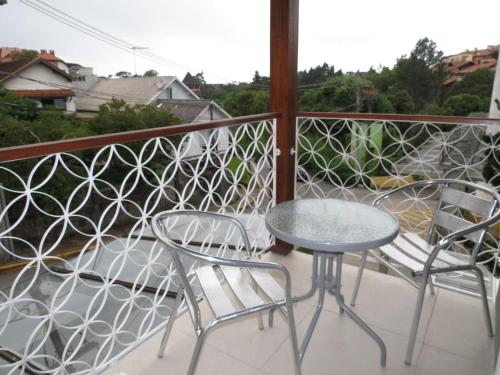 two chairs and a table on a balcony with a view at Olidal Pousada da Serra in Gramado