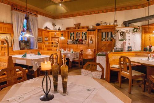 un comedor con mesas, sillas y una vela en Hotel Garni - Gasthof Pillgrab en Sankt Valentin