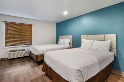 Rúm í herbergi á WoodSpring Suites Abilene