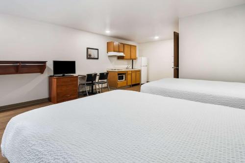 a hotel room with two beds and a kitchen at WoodSpring Suites Abilene in Abilene