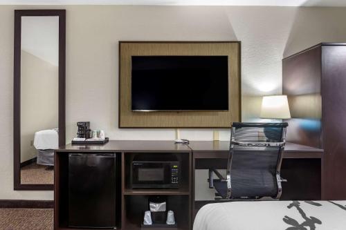 a hotel room with a television and a desk with a chair at Sleep Inn St Robert-Fort Leonard Wood in Saint Robert