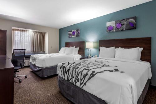 um quarto de hotel com duas camas e uma secretária em Sleep Inn St Robert-Fort Leonard Wood em Saint Robert