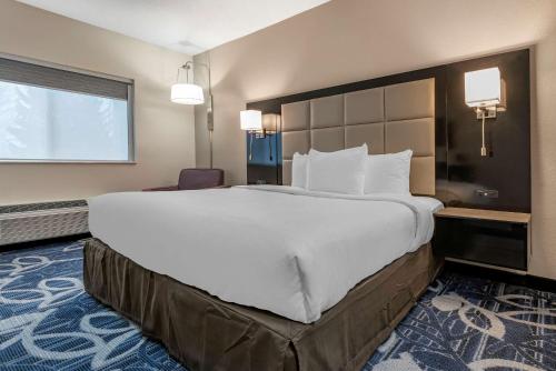 - un grand lit blanc dans une chambre d'hôtel dans l'établissement Comfort Inn & Suites Liverpool - Syracuse, à Liverpool