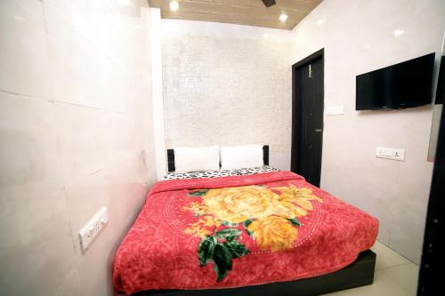 a bedroom with a bed with a red comforter at Hotel Star Light in Amritsar
