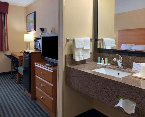 a hotel room with a bathroom with a sink and a television at Quality Inn Ottawa near Starved Rock State Park in Ottawa