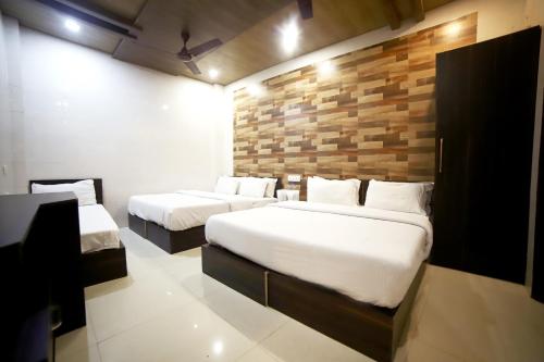 a bedroom with two beds and a brick wall at Hotel Star Light in Amritsar