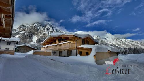 a house covered in snow in front of a mountain at Chalet Leßner in Leutasch