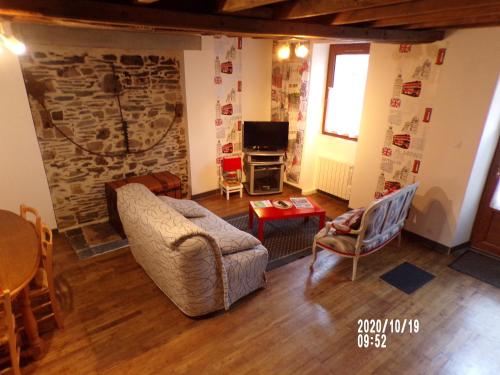 sala de estar con sofá y pared de piedra en gite colorado, en Renac