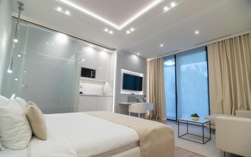 a bedroom with a large bed and a living room at Zala Springs Golf Resort in Zalacsány
