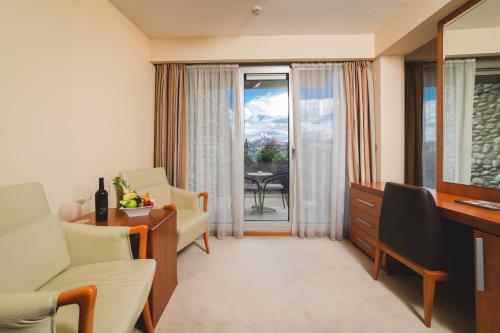 a living room with a couch and a table and chairs at Hotel Podgorica in Podgorica