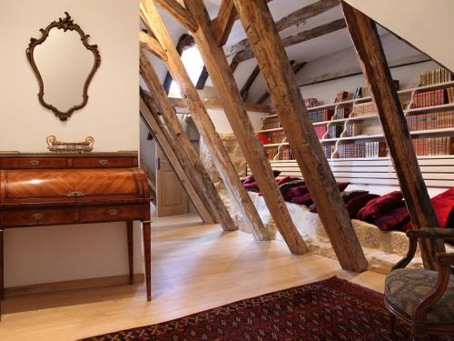 a room with a staircase with a table and a mirror at La Maison des Sarrasins in Beynac-et-Cazenac