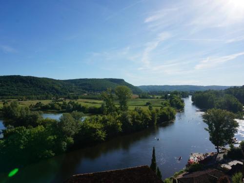 a view of a river with people swimming in it at La Maison des Sarrasins in Beynac-et-Cazenac