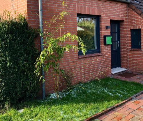 a brick house with a door and a window at Paradiesje 3 in Leer