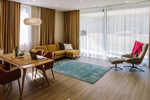 a living room with a couch and a table at Zala Springs Golf Resort in Zalacsány