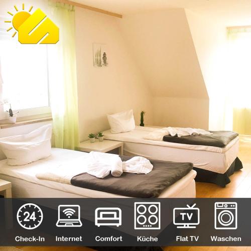 two beds in a room with a window at SUNNYHOME Monteurwohnungen und Apartments nahe Regensburg in Nittendorf