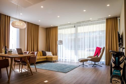 a living room with a couch and a table at Zala Springs Golf Resort in Zalacsány