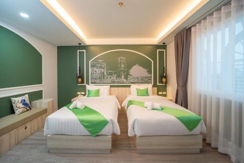 2 Betten in einem Zimmer mit Grün und Weiß in der Unterkunft Peranakan House - SHA Plus in Phuket
