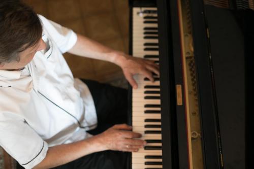 a man playing the keyboard of a piano at Hotel Garni - Gasthof Pillgrab in Sankt Valentin