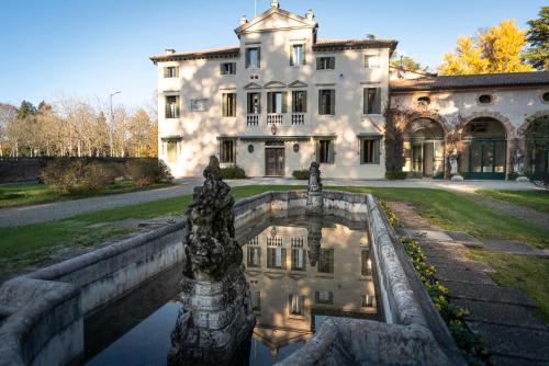 una grande casa con un laghetto di fronte di Villa Vitturi a Maserada sul Piave