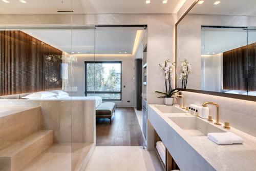 a bathroom with a large sink and a bedroom at The One Acropolis in Athens
