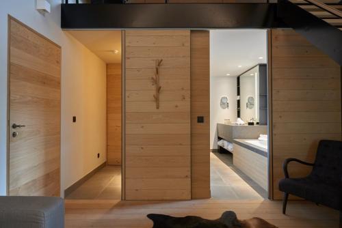 Habitación con una gran puerta de madera en el baño. en Domaine de Naxhelet en Wanze