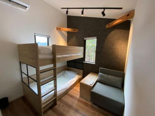 a small room with bunk beds and a couch at Stella House ステラハウス in Fujikawaguchiko