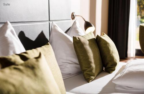 a bunch of pillows sitting on a bed at Sporthotel Grafenwald 4 Sterne Superior in Daun