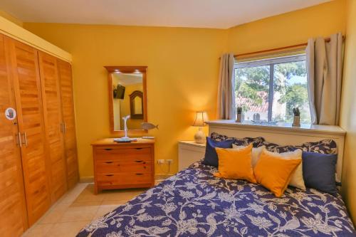 Schlafzimmer mit einem Bett mit blauen und orangefarbenen Kissen in der Unterkunft Beachfront Cadaques Smart Tv Fullkitchenrest in Bayahibe