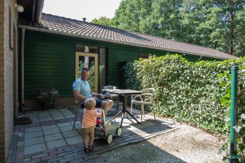 a man and a child playing with a toy car at Vakantiepark Zevenbergen in Heesch