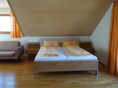 - une petite chambre avec un lit et une chaise dans l'établissement Haus Am Ettenberg, à Frickingen