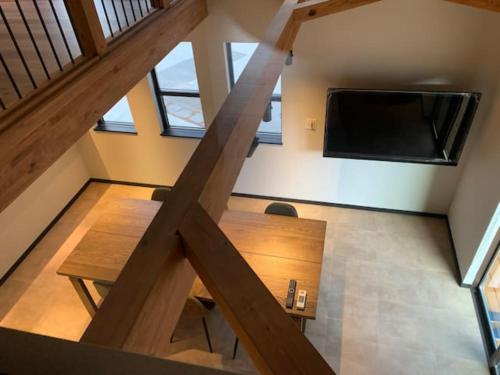a loft with a table and a tv in a room at Stella House ステラハウス in Fujikawaguchiko