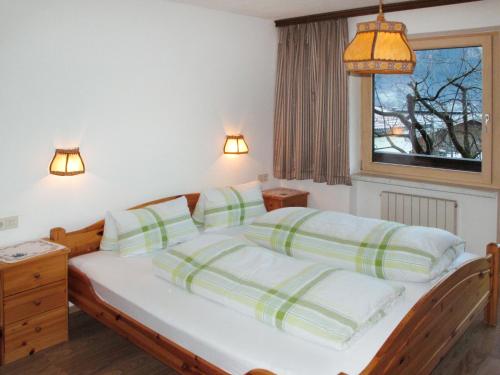 a bedroom with a bed with two pillows and a window at Holiday Home Eberharter by Interhome in Mayrhofen