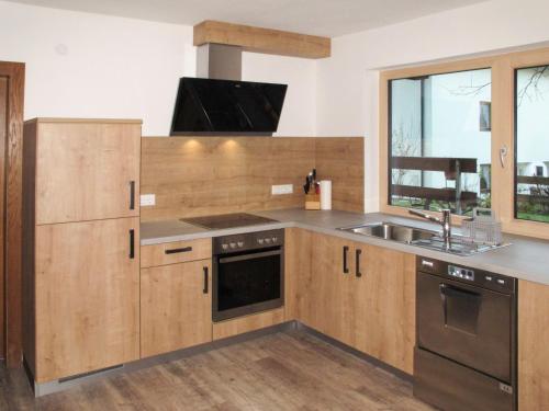 a kitchen with wooden cabinets and a sink at Holiday Home Eberharter by Interhome in Mayrhofen