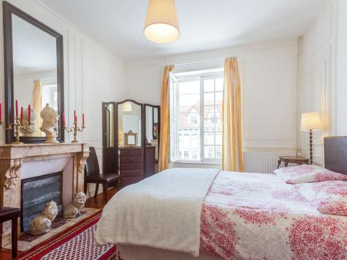 Schlafzimmer mit einem Bett, einem Kamin und einem Spiegel in der Unterkunft Villa Le Cyclamen by Interhome in Courseulles-sur-Mer