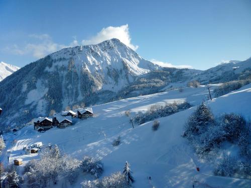 a snow covered mountain with houses in front of it at Studio Soyouz Vanguard-10 by Interhome in Le Corbier