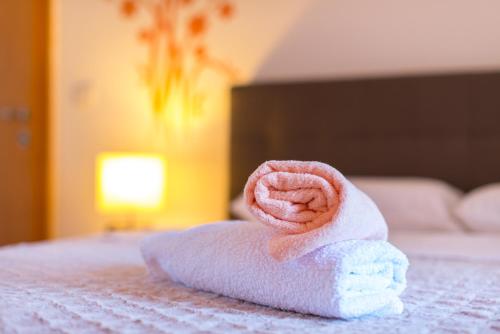 a rolled up towel with a pink coil on a bed at Studio Apartment Vittoria in Lovran