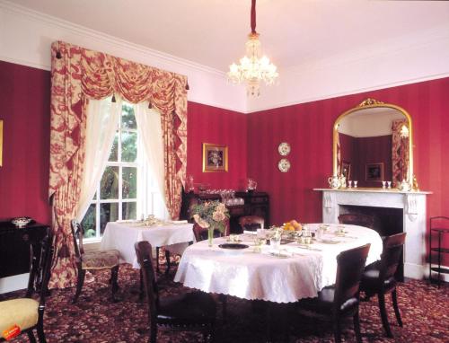 Ivyleigh House في بورتلاويس: غرفة طعام مع طاولتين ومرآة