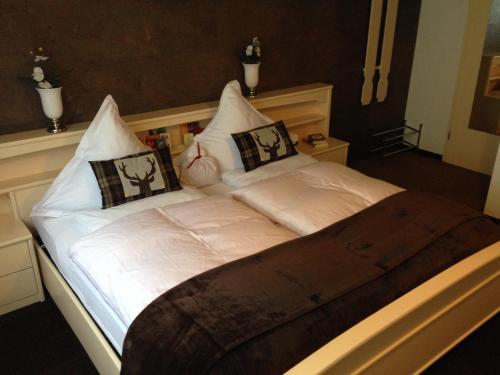 a bed with white sheets and pillows on it at Mosel-Pension Gästehaus Christiane, Brodenbach in Brodenbach