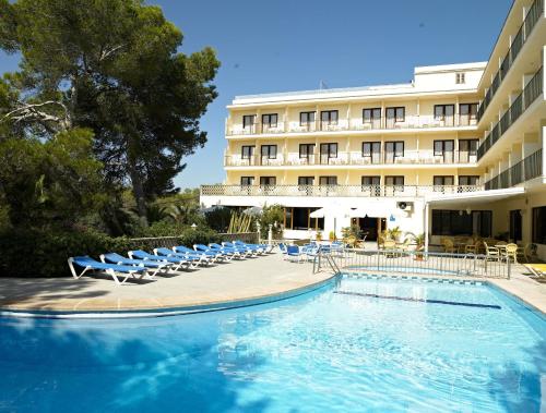 un hotel con piscina e sedie e un edificio di Hotel Condemar a Portopetro