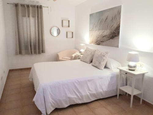 ラ・オリーバにあるVilla Palmarsuの白いベッドルーム(白いベッド1台、椅子付)