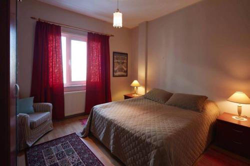 ein Schlafzimmer mit einem Bett, einem Fenster und einem Stuhl in der Unterkunft Cozy Apartment Next to Taksim Square in Istanbul