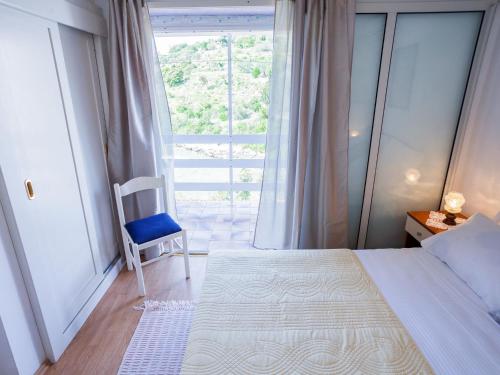 a bedroom with a bed and a chair and a window at Holiday Home Nataly by Interhome in Vela Luka
