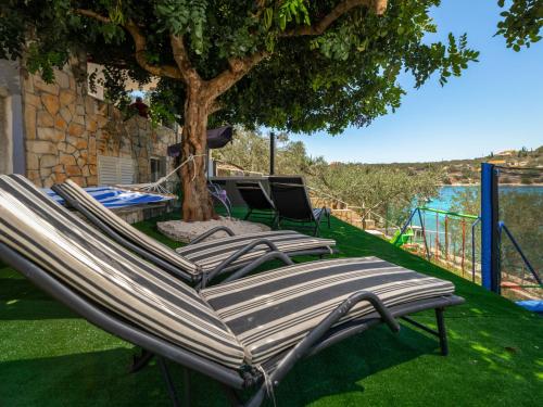 a group of chairs and a hammock under a tree at Holiday Home Nataly by Interhome in Vela Luka