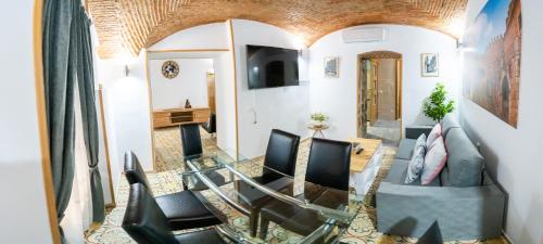 a living room with chairs and a glass table at Art & SUITE Apartment Cáceres in Cáceres