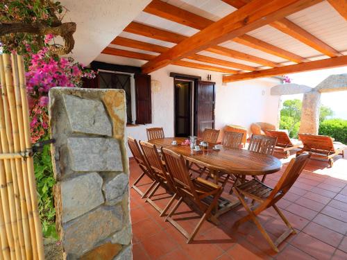una mesa de madera y sillas en un patio en Holiday Home Ville Sant'Elmo - REI240 by Interhome, en Monte Nai